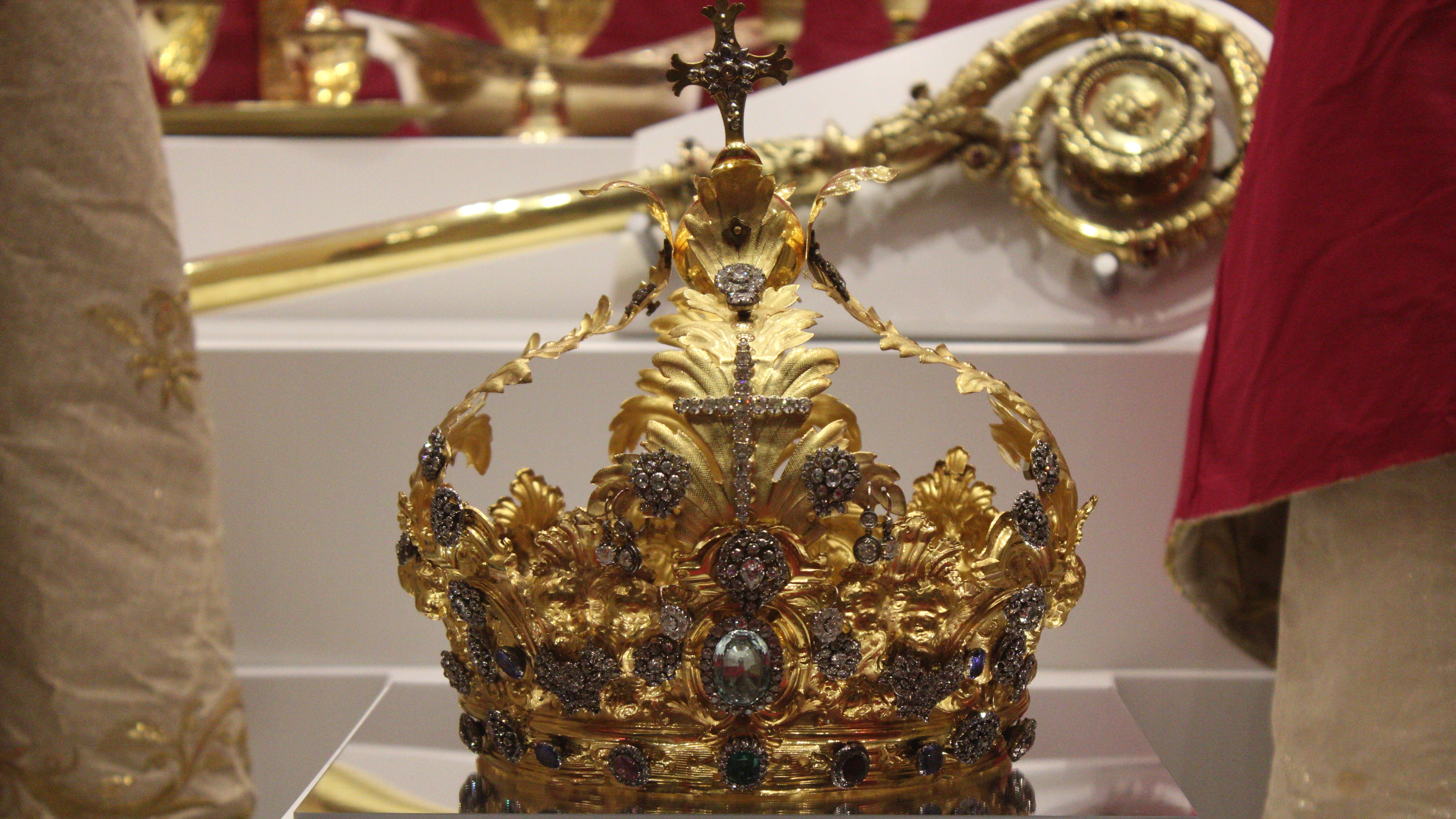 Corona in oro riccamente decorata con gemme e croce, esposta nel museo del Santuario.