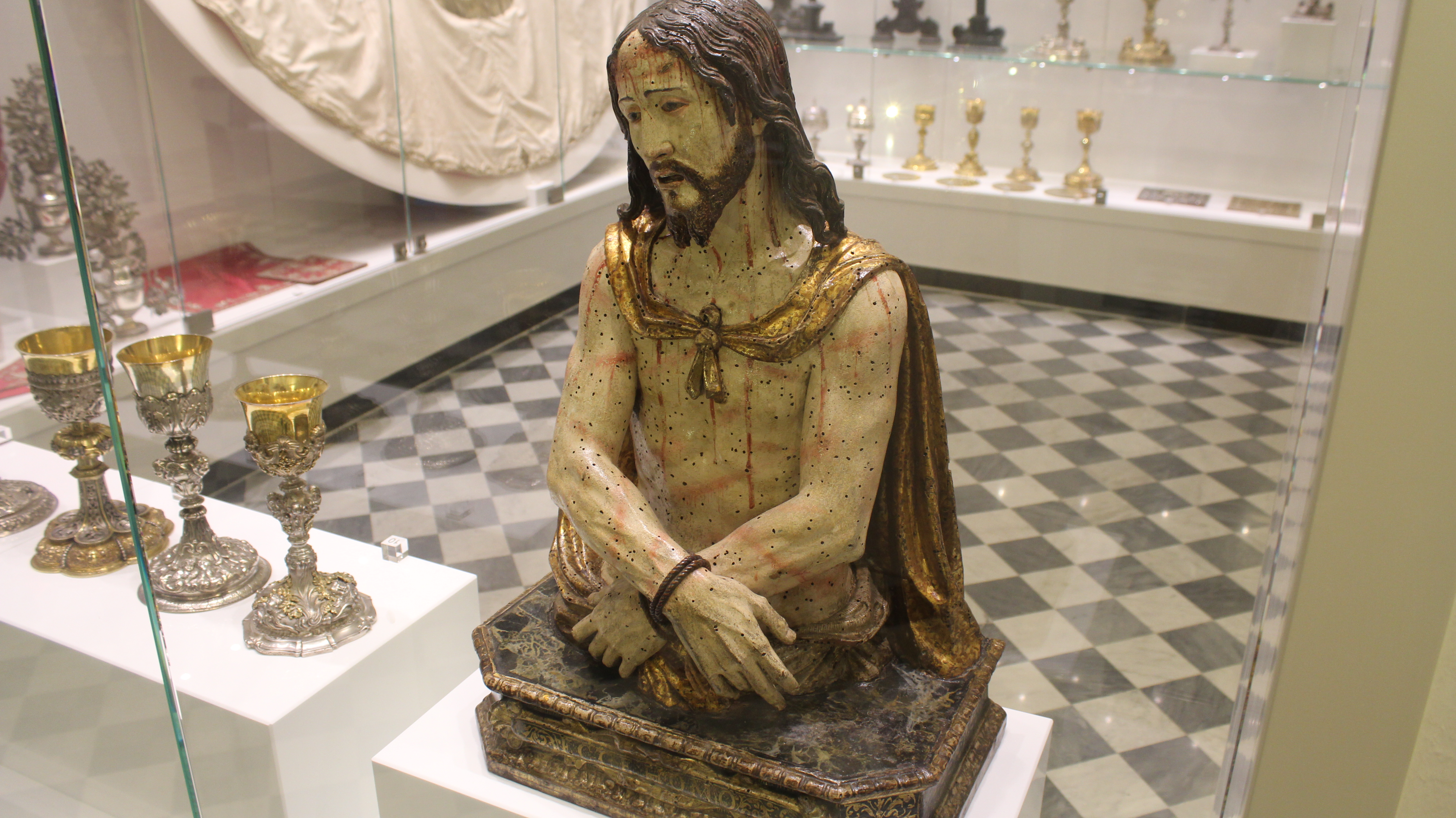 Scultura di Cristo coronato di spine, esposta in una teca museale.